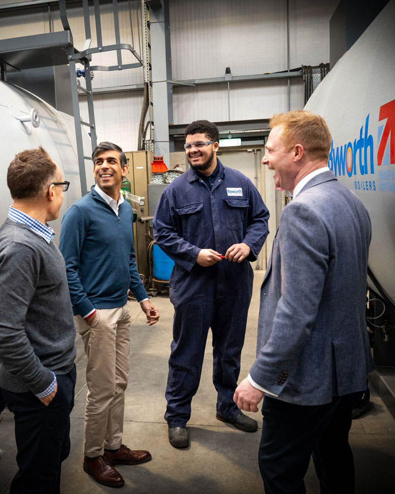 Rishi Sunack stood next to an industrial boiler chatting with the Byworth Boilers team